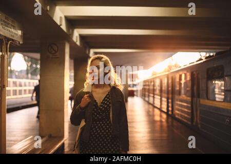 Müde junge Frau, die auf die U-Bahn Station Stockfoto