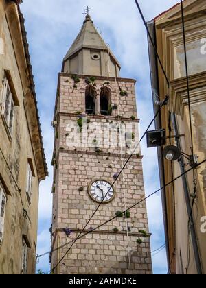 Glockenturm in der Mitte einer Archivierung Stadt. Turm ist hoch über andere Gebäude. Von der Unterseite erfasst. Alle Gebäude sind Co Stockfoto