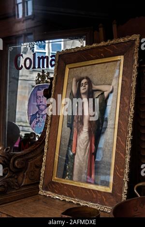 Gemälde einer jungen Frau und Spiegel mit George V Werbung Colman's Senf im Fenster einer Antique Shop in Edinburgh, Schottland, Großbritannien. Stockfoto