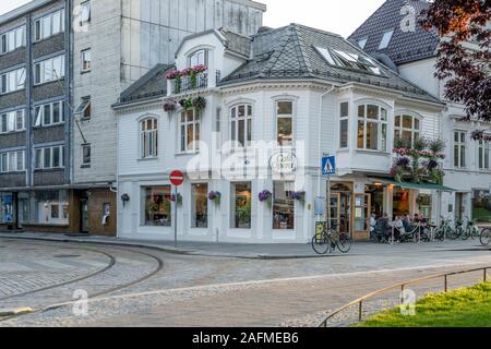 BERGEN, Norwegen - 19 Juli 2019: touristische Stadt Stadtbild mit Menschen an Tischen aus malerischen an der Ecke Cafe in der Stadt Zentrum Nachbarschaft, Schuß Stockfoto