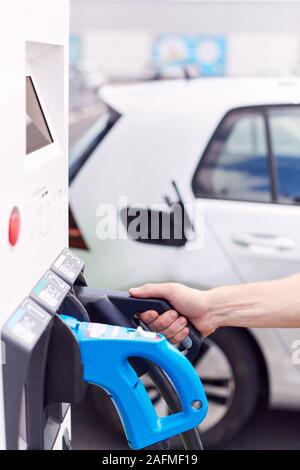 Nahaufnahme von Mann befestigen Sie das Netzkabel auf Umweltfreundliche Emissionsfreie Elektroauto Stockfoto