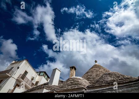 Dächer von truli, typisch weiß getünchten zylindrische Häuser in Alberobello, Apulien, Italien mit tollen blauen Himmel mit Wolken und Sonne Stockfoto