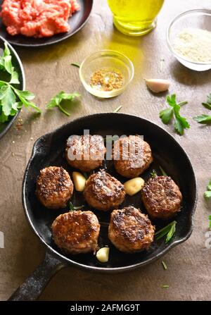 Hackfleisch Schnitzel in der Pfanne über braunen Hintergrund. Stockfoto