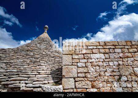 Dächer von truli, typisch weiß getünchten zylindrische Häuser in Alberobello, Apulien, Italien mit tollen blauen Himmel mit Wolken und alten Stein schöne gemauerte Wand Stockfoto