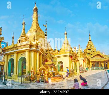 YANGON, MYANMAR - 17. FEBRUAR 2018: Sule Pagode ist eine der ältesten und am meisten verehrten buddhistischen Komplex in der Stadt mit schönen goldenen Stupa und nume Stockfoto