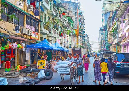 YANGON, MYANMAR - Februar 17, 2018: Der Markt Straßen von Chinatown erkunden, voller kleiner Läden, Stände, Cafés, Lagerhallen, Touristenhotels und Arbeit Stockfoto