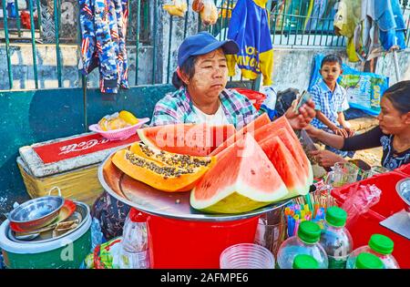 YANGON, MYANMAR - Februar 17, 2018: Das Fach mit Scheiben Wassermelone und Papaya in Chinatown Marktstand, am 17. Februar in Yangon Stockfoto