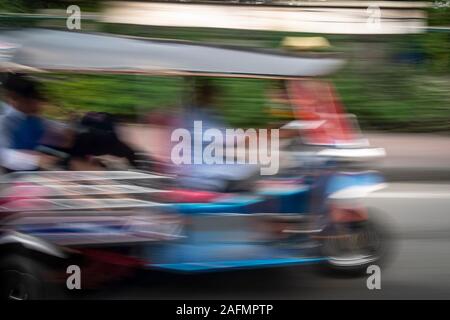 Tuktuk an Geschwindigkeit entlang der Straße unterwegs in Bangkok, Thailand Stockfoto