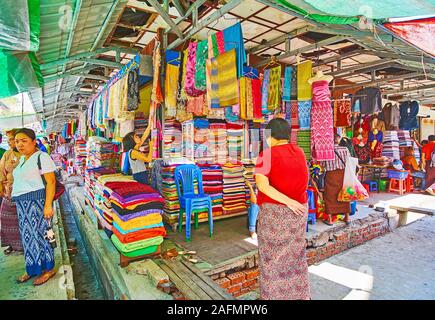 YANGON, MYANMAR - 17. FEBRUAR 2018: Die breite Palette der traditionellen burmesischen Paso longyi (männlich und weiblich) htamein und Stoff für die Herstellung von longyi im Sta Stockfoto