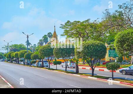 YANGON, MYANMAR - 17. FEBRUAR 2018: Die Linie der Grünen getrimmten Bäumen, wächst inmitten der U Htaung Bo Road, die zur Shwedagon Pagode, am 17. Februar i Stockfoto