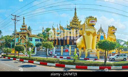 YANGON, MYANMAR - 17. FEBRUAR 2018: Panorama der North Gate der Shwedagon Pagode, die von zwei riesigen chinthe Lions Statuen bewacht und mit spl eingerichtet Stockfoto