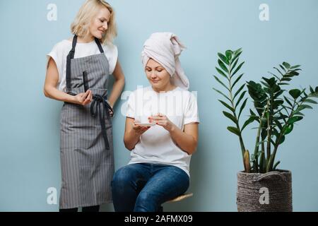 Friseur mit ihren Client, Zeit zu töten, während Haare bleichen. Stockfoto