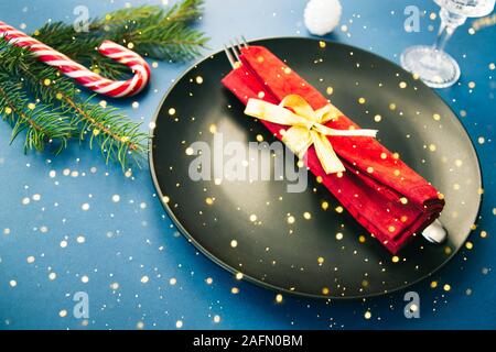 Weihnachten Tisch Einstellung mit Weihnachten und Teller, Gabel und roter Baumwolle Serviette mit Schleife. Weihnachten Hintergrund Stockfoto