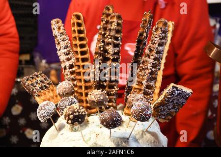 Verschiedene leckere Waffeln auf einem Stock in Schokolade oder mit Puderzucker bereit, in einem Weihnachtsmarkt in Vilnius zu essen Abblendlicht Stockfoto