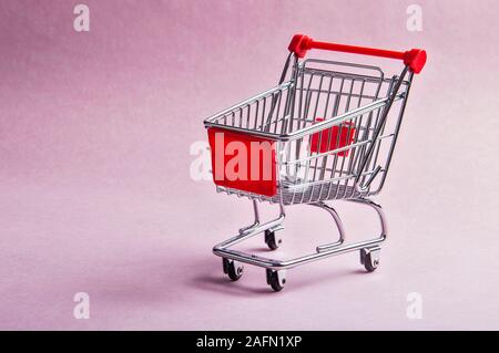 Einen Warenkorb oder Trolley auf rosa Hintergrund Stockfoto