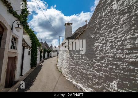 Dächer und Tore von truli, typisch weiß getünchten zylindrische Häuser in Alberobello, Apulien, Italien mit tollen blauen Himmel mit Wolken, Street View Stockfoto