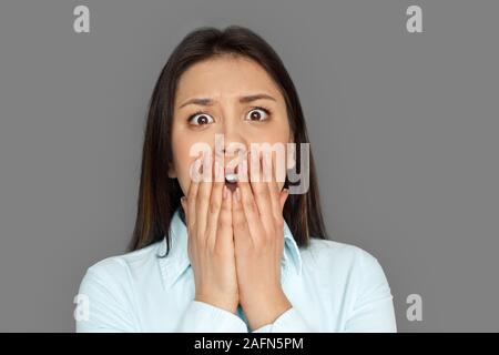 Freestyle. Junge Frau, die isoliert auf grauen schreiend in der Nähe Angst-up Stockfoto