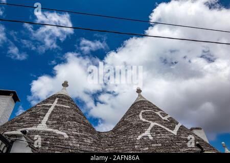 Dächer von truli, typisch weiß getünchten zylindrische Häuser in Alberobello, Apulien, Italien mit tollen blauen Himmel mit Wolken und Sonne Stockfoto