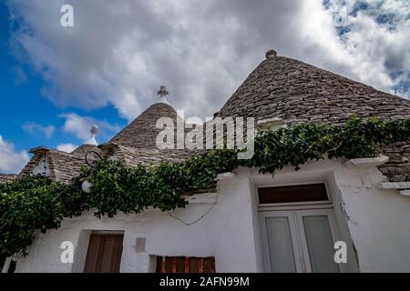 Dächer von truli, typisch weiß getünchten zylindrische Häuser in Alberobello, Apulien, Italien mit tollen blauen Himmel mit Wolken und Sonne Stockfoto