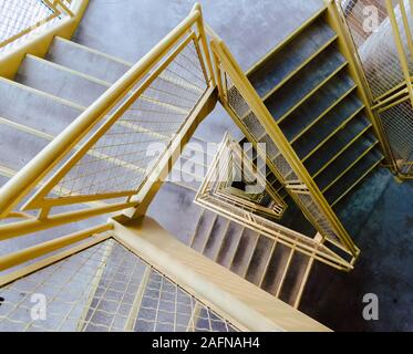 Hohe Winkelaufnahme einer Treppe mit gelbem Geländer Stockfoto