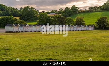 Strand Hütten auf dem Gras in der Nähe der Promenade im Broadsands, Torbay, England, Großbritannien Stockfoto