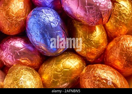 Viele Schokolade Ostereier in blau, lila, orange, rosa und golden wrap Folie verpackt Stockfoto