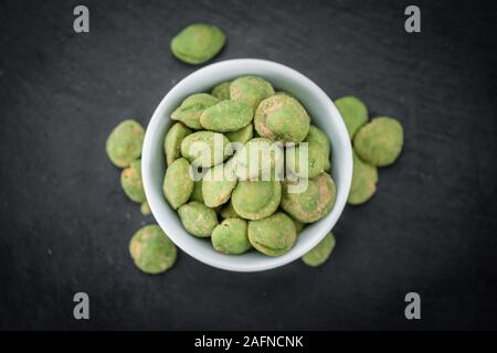 Teil der Wasabi coated Peanuts auf einem urigen Schiefer Tafel (selektive Fokus, Nahaufnahme) Stockfoto