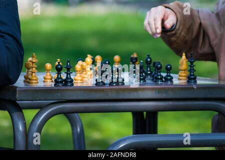 Person, die bereit ist, einen Schritt in ein Schach zu nehmen Spiel mit einem verschwommenen Hintergrund Stockfoto