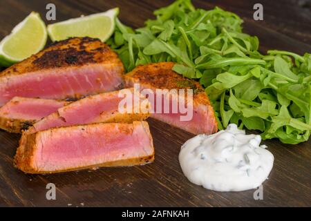 Cilantro Kalk Thunfisch Steak mit saurer Sahne Sauce und Rucola Stockfoto