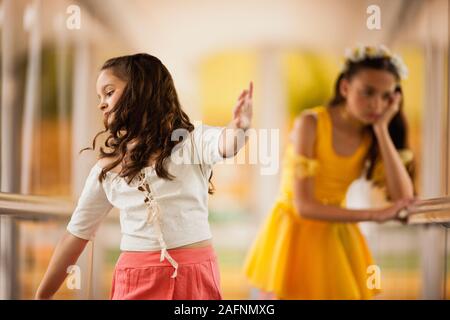 Mädchen schmollen, wie sie Uhren ihre Schwester tanzen. Stockfoto