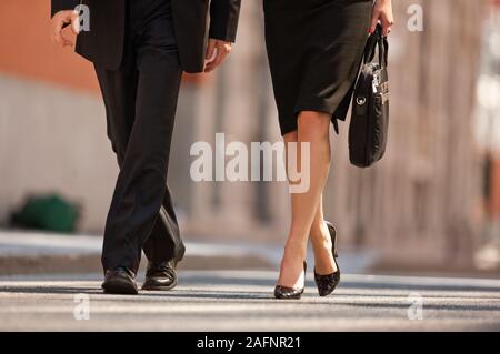 Zwei Geschäftsleute Spaziergang im Freien, einer Straße, einer trägt einen Koffer. Stockfoto