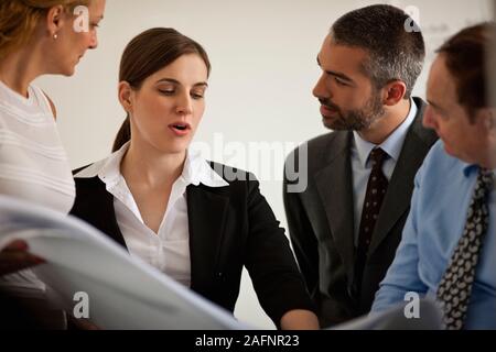 Kleine Gruppe von Geschäftsleuten in einer Sitzung auf Baupläne. Stockfoto