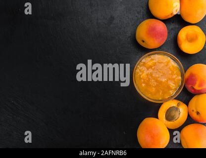 Teil der Aprikosenmarmelade auf einem urigen Schiefer Tafel (selektive Fokus, Nahaufnahme) Stockfoto