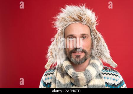 Hipster Mode Winter Zubehör. Reifen stattlichen Hipster mit Bart und Schnurrbart gerne ungewöhnliche Dinge tragen. In seinem eigenen Stil. Man bärtige hipster Verschleiß furry Hut gestreiften Schal und gestrickte Pullover. Stockfoto