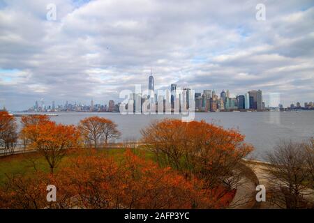 Auf die Skyline von New York City mit der Bäume im Herbst von Ellis Island in USA, Oktober 15,2018 Stockfoto