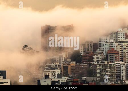 Gebäude, die von Nebel am Ende eines warmen Nachmittag im nördlichen Teil der Stadt Quito umgeben Stockfoto