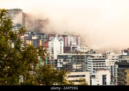 Gebäude, die von Nebel am Ende eines warmen Nachmittag im nördlichen Teil der Stadt Quito umgeben Stockfoto