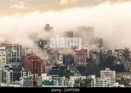 Gebäude, die von Nebel am Ende eines warmen Nachmittag im nördlichen Teil der Stadt Quito umgeben Stockfoto