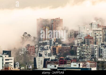 Gebäude, die von Nebel am Ende eines warmen Nachmittag im nördlichen Teil der Stadt Quito umgeben Stockfoto