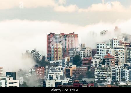 Gebäude, die von Nebel am Ende eines warmen Nachmittag im nördlichen Teil der Stadt Quito umgeben Stockfoto