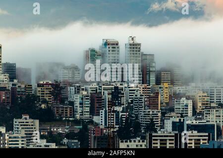 Gebäude, die von Nebel am Ende eines warmen Nachmittag im nördlichen Teil der Stadt Quito umgeben Stockfoto