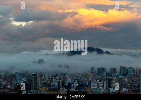 Gebäude, die von Nebel am Ende eines warmen Nachmittag im nördlichen Teil der Stadt Quito umgeben Stockfoto