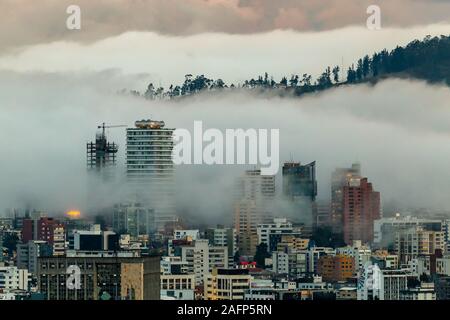 Gebäude, die von Nebel am Ende eines warmen Nachmittag im nördlichen Teil der Stadt Quito umgeben Stockfoto