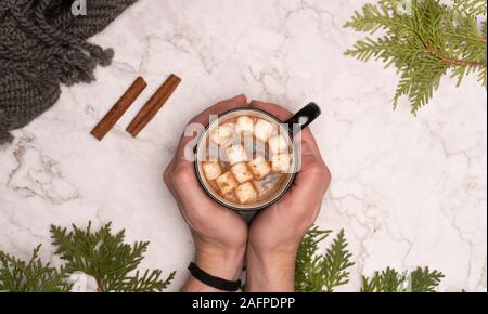 Weibliche holding Tasse heiße Schokolade mit Marshmallows auf Zähler von oben Stockfoto
