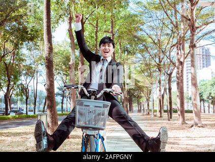 Happy Geschäftsmann Reiten Fahrrad auf Urban Street zu arbeiten Stockfoto