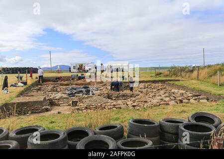 Eine archäologische Stätte in der Nähe der Steinesteine von Stenness auf den Orkney Inseln. Die Stätte liegt zwischen den Steinen und dem Ring von Brodgar. Stockfoto