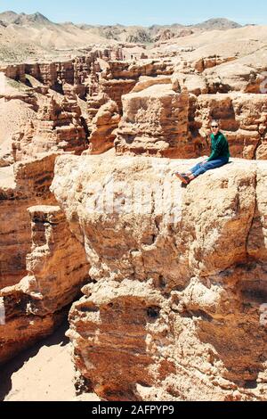 Touristen, die auf dem Felsen in der Region Charyn Canyon, Almaty, Kasachstan - Mai, 2018. Stockfoto