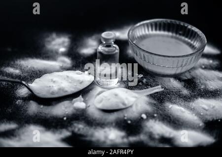 Gesichtsmaske oder Packung Backpulver in eine Glasschüssel auf Holz- Oberfläche zusammen mit Pulver und einige Kokosöl in einem Glasfläschchen. Verwendet für Stockfoto