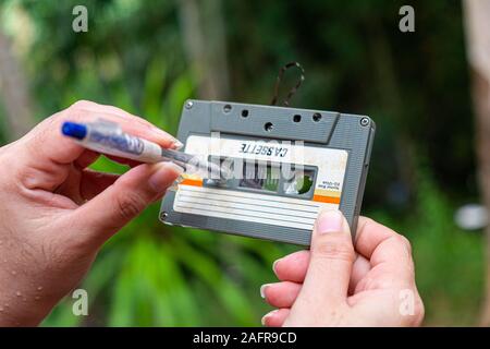 Frauen Zurückspulen einer Kassette kompakte Vintage auf unscharfen Hintergrund, schließen Sie die Einrichtung des alten Tonbänder, Retro Stockfoto