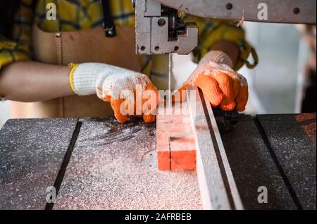 Frauen stehen ist Handwerk Holz arbeiten an einer Werkbank mit Bandsägen power tools bei Tischler Maschine in der Werkstatt, Arbeiter sägen Bretter aus wi Stockfoto